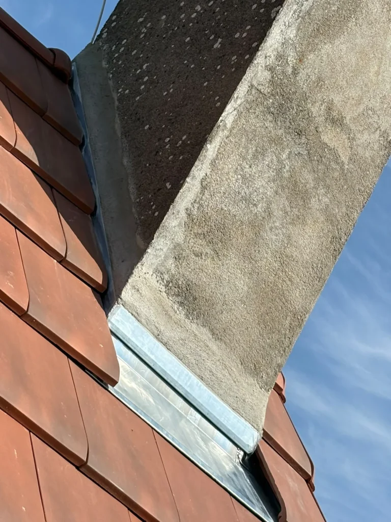 Détail d’un raccord de zinguerie entre les tuiles et une cheminée